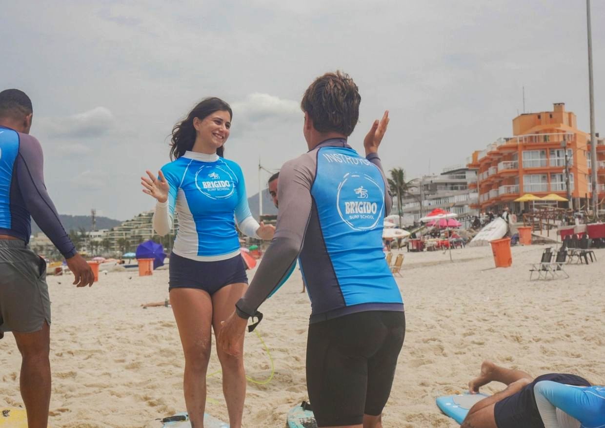 Instrutor da Brigido comemorando com aluna na areia depois da aula