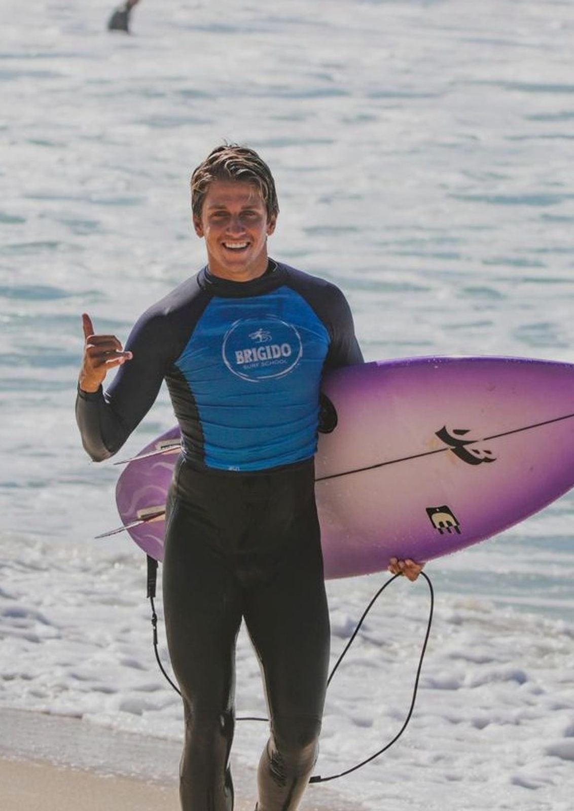 Diego Brigido saindo do mar com a prancha